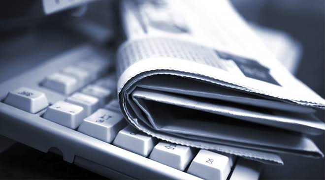 periodico de noticias encima de una ordenador